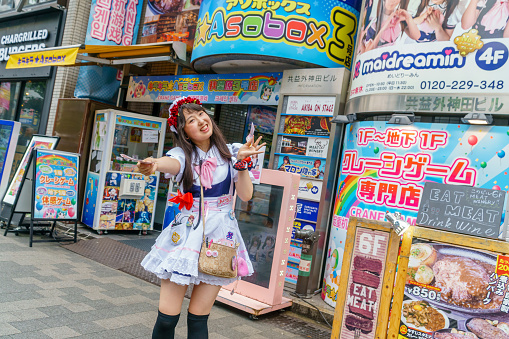 Chiyoda City, Japan - May 22, 2023: Pedestrians walk under the colorful commercial signs lining Sotokanda in Akihabara District. Spring afternoon in the Tokyo Metropolis.