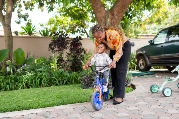 istock Toddler getting on bicycle with mother helping at home 1408227117