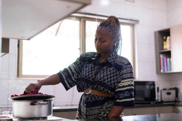 istock Young woman cooking with pot on stove in kitchen 1408230090