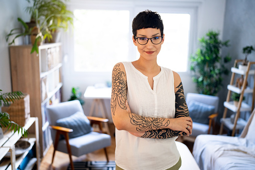 Portrait of confident and urban young Caucasian woman, with short hair and sleeve tattoo