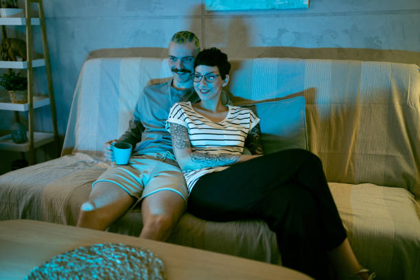istock Urban couple watching TV while sitting on the sofa 1408231496