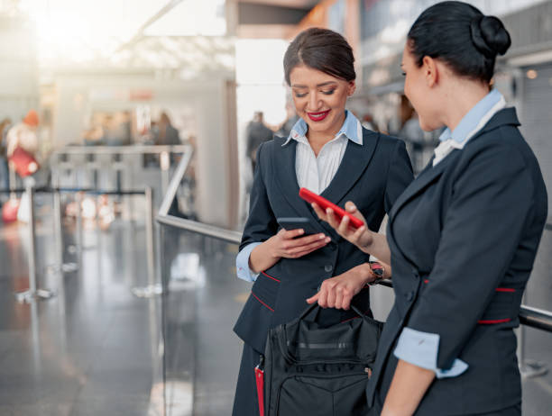 istock Two beautiful stewardesses using phones and waiting for the flight 1408233040