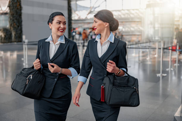 터미널에서 이야기하는 가방을 들고 예쁜 승무원을 웃고 있습니다. - cabin crew 뉴스 사진 이미지