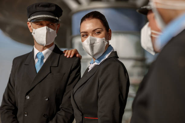 istock Pilot and stewardess in masks looking at their colleagues 1408233073