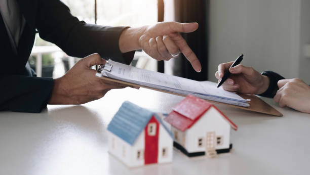 Real estate agent with house model hand putting signing contract,have a contract in place to protect it,signing of modest agreements form in office.Concept real estate,moving home or renting property agente de bienes raíces con el modelo de la casa a mano poniendo contrato de firma, tener un contrato en su lugar para protegerlo, firma de acuerdos modestos forma en la oficina. concepto de bienes raíces, mudanza de casa o alquiler de propiedad