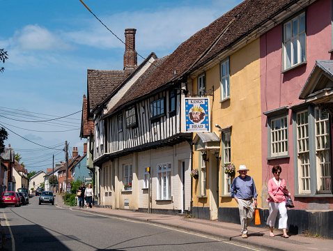 People walking along the High Street in Bildeston, a pretty village in Suffolk, Eastern England, on a sunny day. Bildeston has many old buildings and was famous during the 15th century for its ‘blue cloth’.