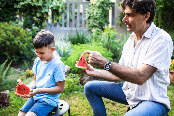 istock Father and son eating watermelon 1408235372