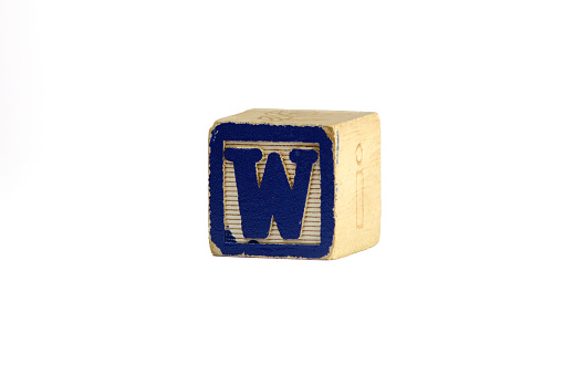Vintage wooden letter W block, blue and white, photographed against a white background