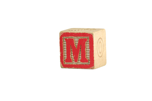 An old vintage wooden letter M block, red and white, photographed against a white background