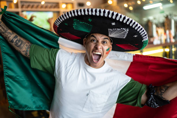 Fan man celebrating winning holding Mexican flag