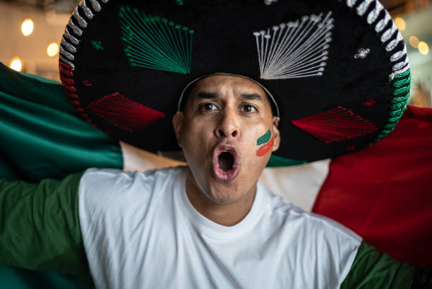 istock Fan man celebrating winning holding Mexican flag 1408240148