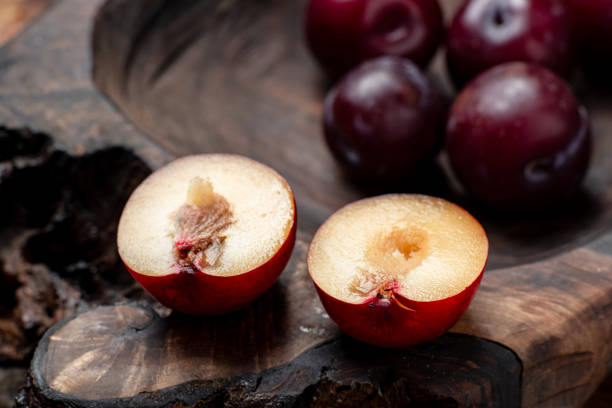 istock Fresh sliced red plums on a dark wooden background. 1408240944
