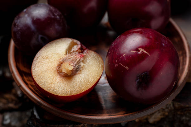 prugne rosse fresche affettate su uno sfondo di legno scuro. - red potato isolated raw potato raw foto e immagini stock