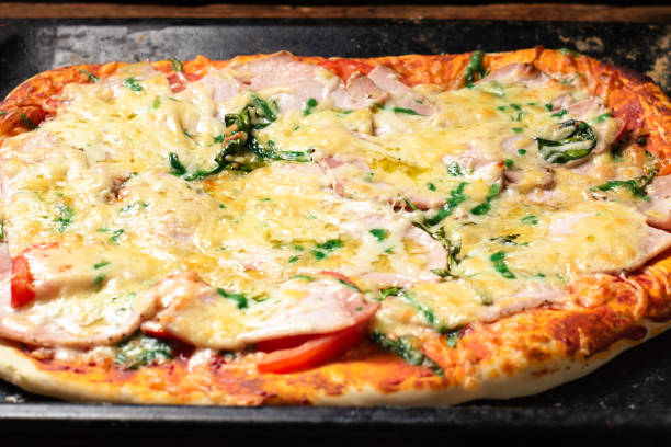 istock Homemade pizza on a baking sheet. Pizza with sausage, tomatoes, cheese. 1408240980