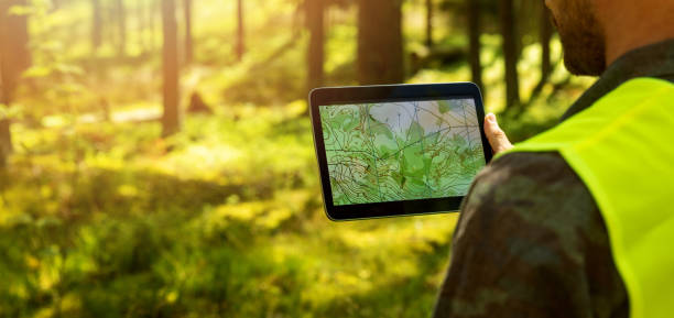 człowiek pracujący z danymi mapy topograficznej na cyfrowym tablecie w lesie. baner z miejscem na kopiowanie - physical geography zdjęcia i obrazy z banku zdjęć