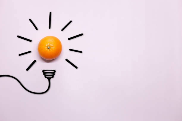 istock Creative thinking ideas and innovation concept. A ball of orange with a light bulb symbol on a lilac background. Time for a healthy diet 1408242374