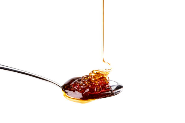 Delicious honey dripping on a teaspoon stock photo