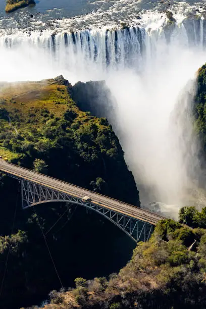 Helicopter view of the magnificent Victoria falls in Africa and a nearby bridge connecting the cliffs