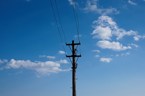 Old fashioned utility pole. Electric cables attached to the pole