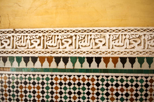 detalhes de close-up da parede de padrão cerâmico e esculpida em pedra da tumba de moulay ismail. as inscrições árabes são esculpidas na pedra. - bronze decor tile mosaic - fotografias e filmes do acervo