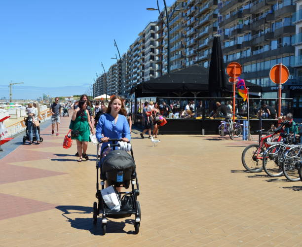 hermosa madre caminando por el dique del paseo marítimo blankenberge - beach family boardwalk footpath fotografías e imágenes de stock