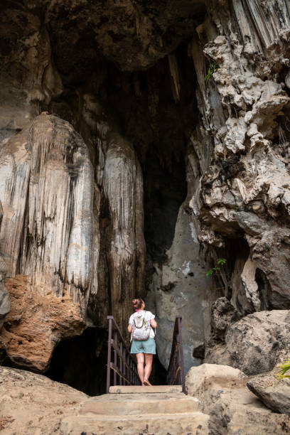 istock Young tourist entering a huge cave. 1408252286