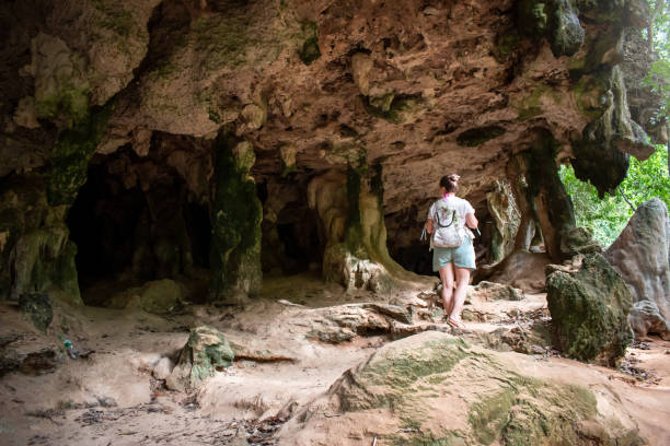 istock Young woman walking towards a cave. 1408253279