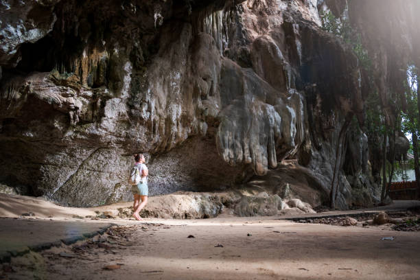 istock Young woman walking towards a cave. 1408253318
