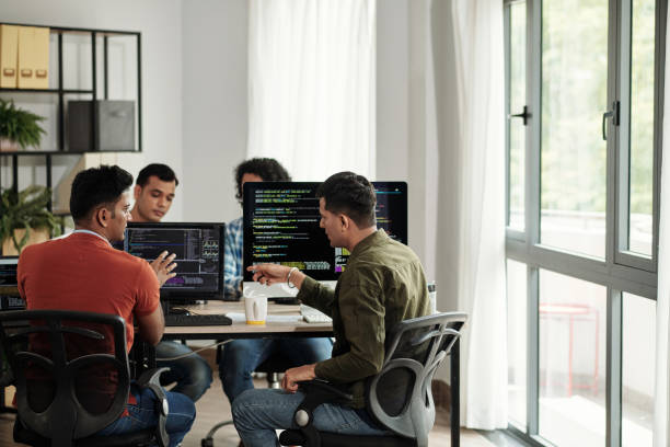 developers discussing programming code - kodlama stok fotoğraflar ve resimler