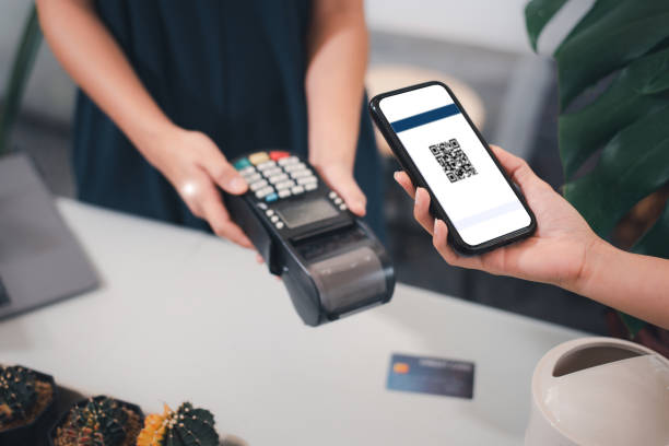 Businesses pay by scanning a QR code in a restaurant,, Customer paying with qr code on smartphone screen NFC payment technology at market shop. stock photo