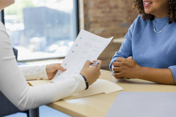 Midsection Of Business People At Desk In Office