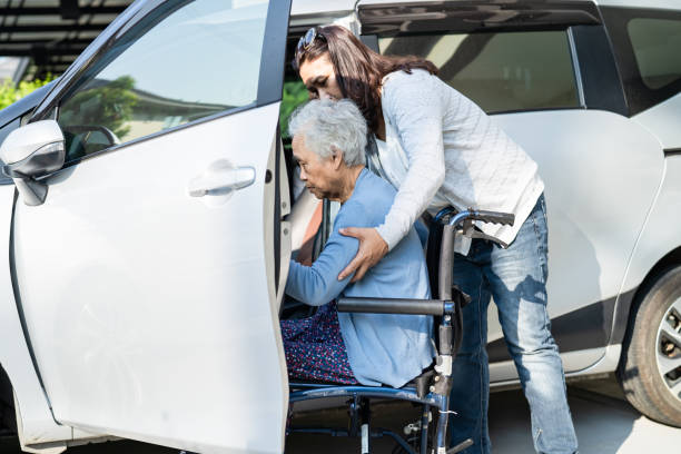 Asian senior or elderly old lady woman patient sitting on wheelchair prepare get to her car, healthy strong medical concept. stock photo