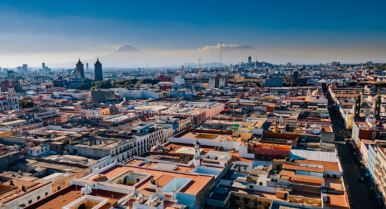 Aerial view of the city Puebla in Mexico with a Popocatepetl volcano in the background .