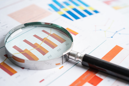 Magnifying glass on charts graphs paper. Financial development, Banking Account, Statistics, Investment Analytic research data economy, Stock exchange trading, Business office concept.