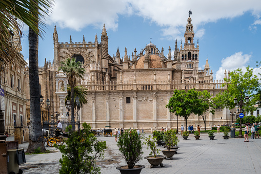 Seville, Spain -- MaY 15, 2022. A wide angle shot of the Seville Cathedral and the town square on a spring day.