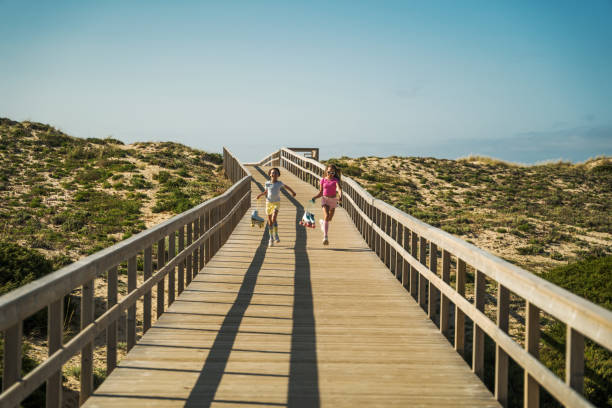 istock Child sisters spending time together and running through the bridge after roller skating 1408267163