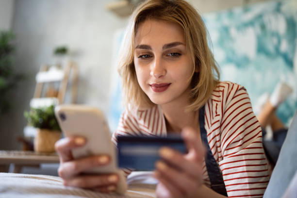 istock Caucasian woman using mobile phone while shopping online 1408268597