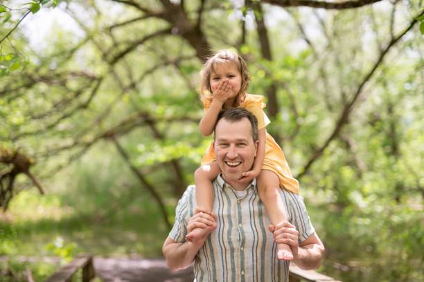 istock Father with his daughter having fun outside in forest 1408270363
