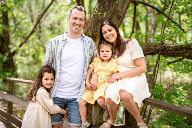istock Father and mother with the daughters having fun outside in forest 1408270428