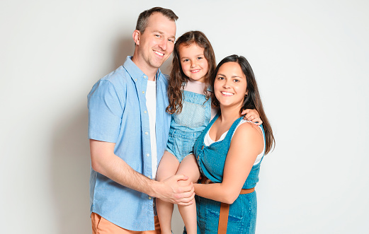 A family with his daughter girl on studio white background