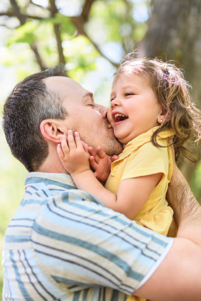 Father with his daughter having fun outside in forest