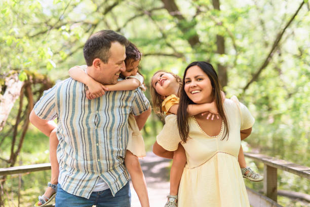 istock Father and mother with the daughters having fun outside in forest 1408270628