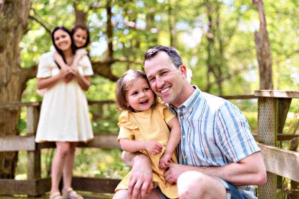 istock Father and mother with the daughters having fun outside in forest 1408270714
