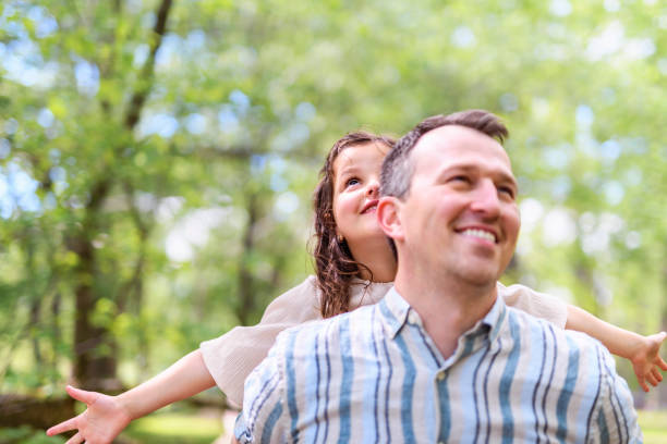 istock Father with his daughter having fun outside in forest 1408270965