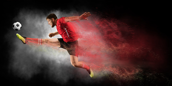 Soccer player in action on black background