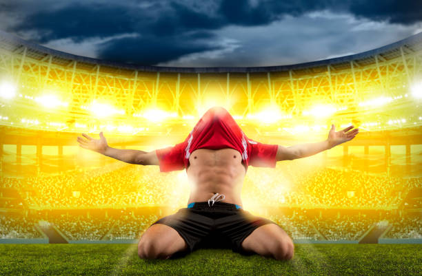 Young athletic man training dribbling technique in motion on green lash field in neon light against white studio background. Concept of professionals sport, competition, tournament, energy, action. Ad