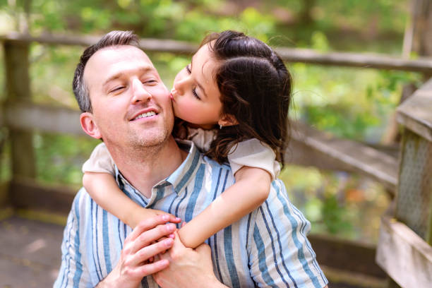 istock Father with his daughter having fun outside in forest 1408270983