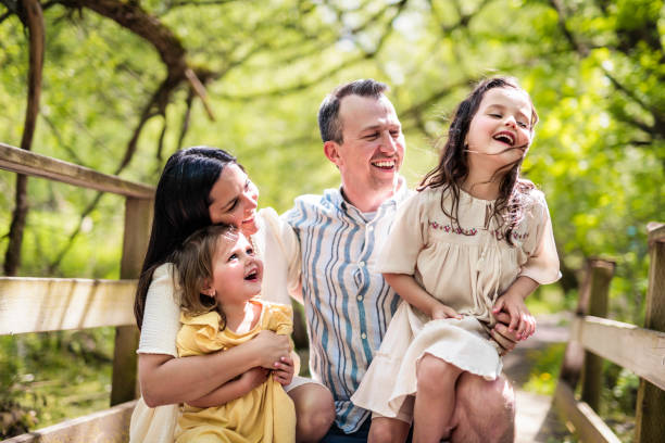 istock Father and mother with the daughters having fun outside in forest 1408271614