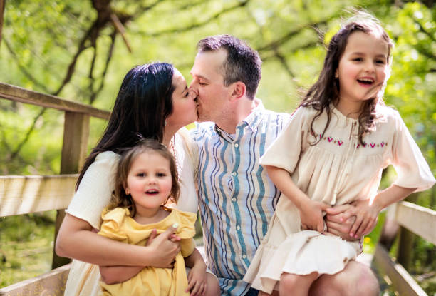 istock Father and mother with the daughters having fun outside in forest 1408271749