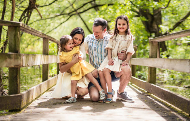 istock Father and mother with the daughters having fun outside in forest 1408271771